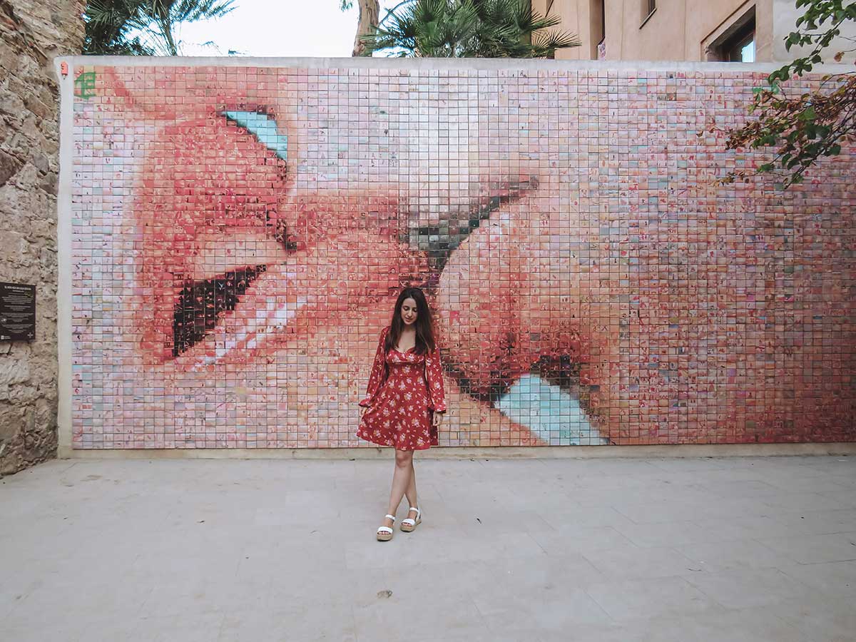 26 Most Instagrammable Places in Barcelona 12 Woman posing in front of the Kiss wall in Barcelona.
