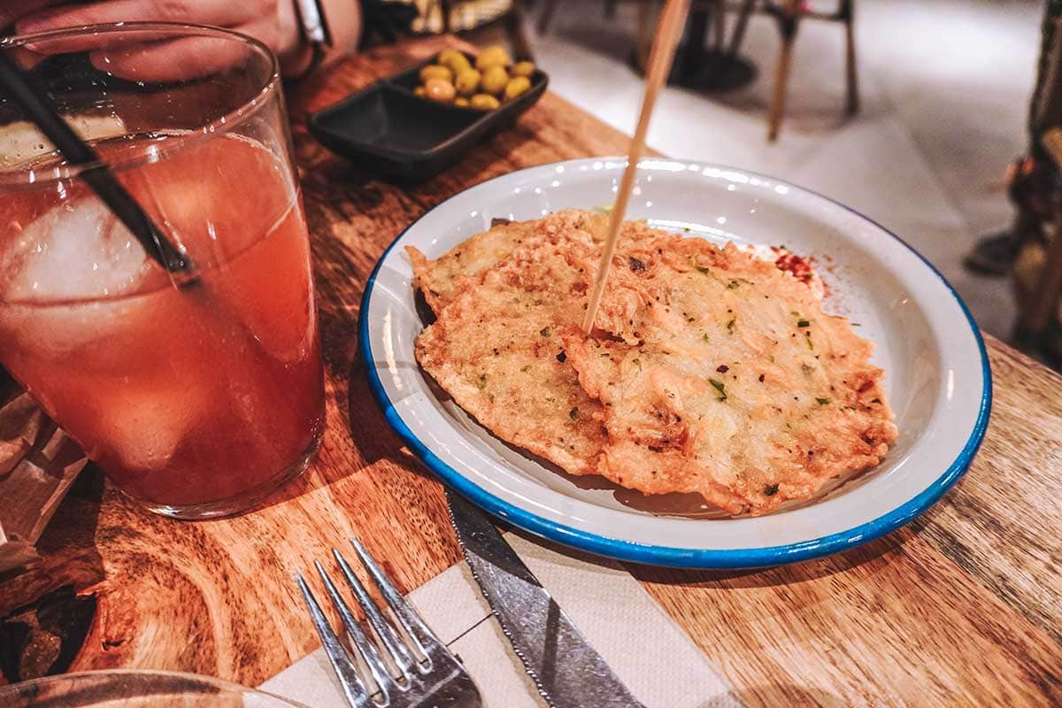 Shrimp fritters next to a tinto de verano drink.