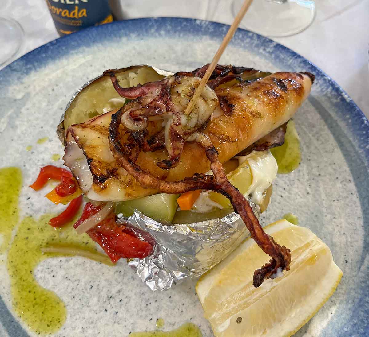 Grilled squid with jacket potato and vegetables.