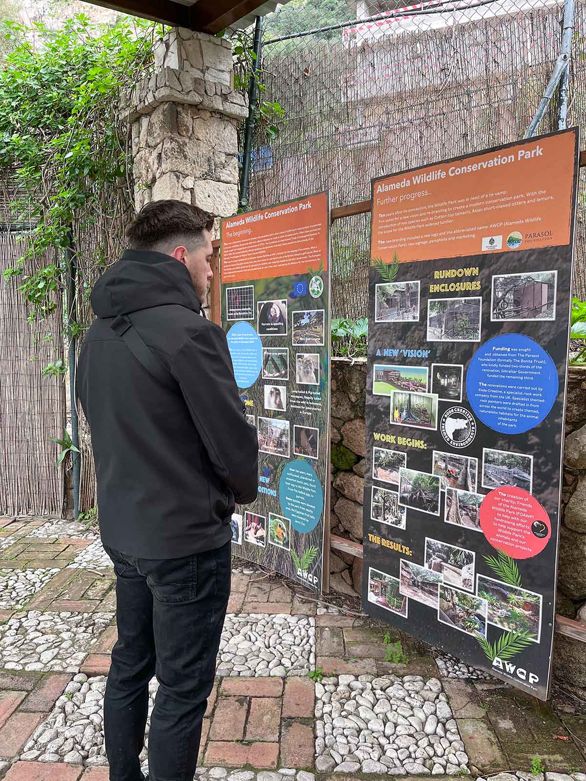 10 Best Things to Do in Gibraltar (Itinerary Included) 16 Man reading information about the Alameda Wildlife Conservation Park in Gibraltar.