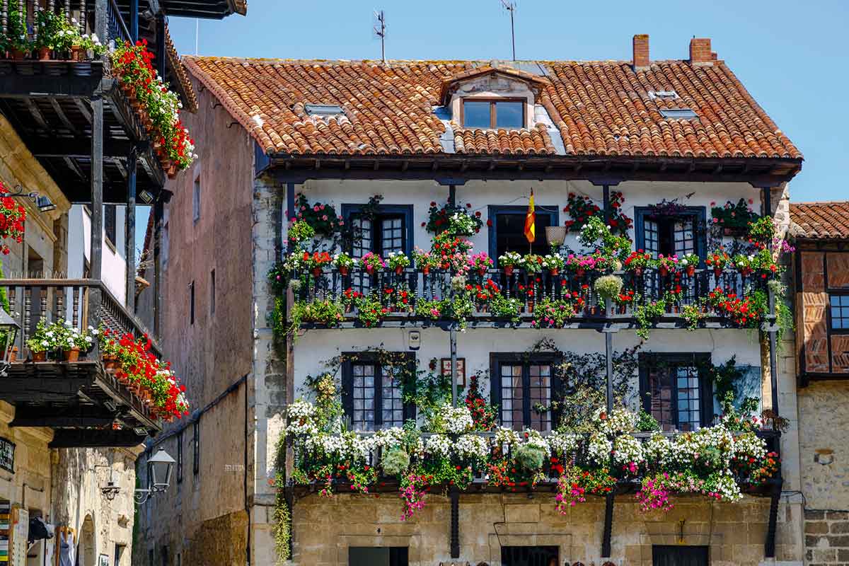 A beautiful building with balconies decorated with flowers in Santillana del Mar, Spain.