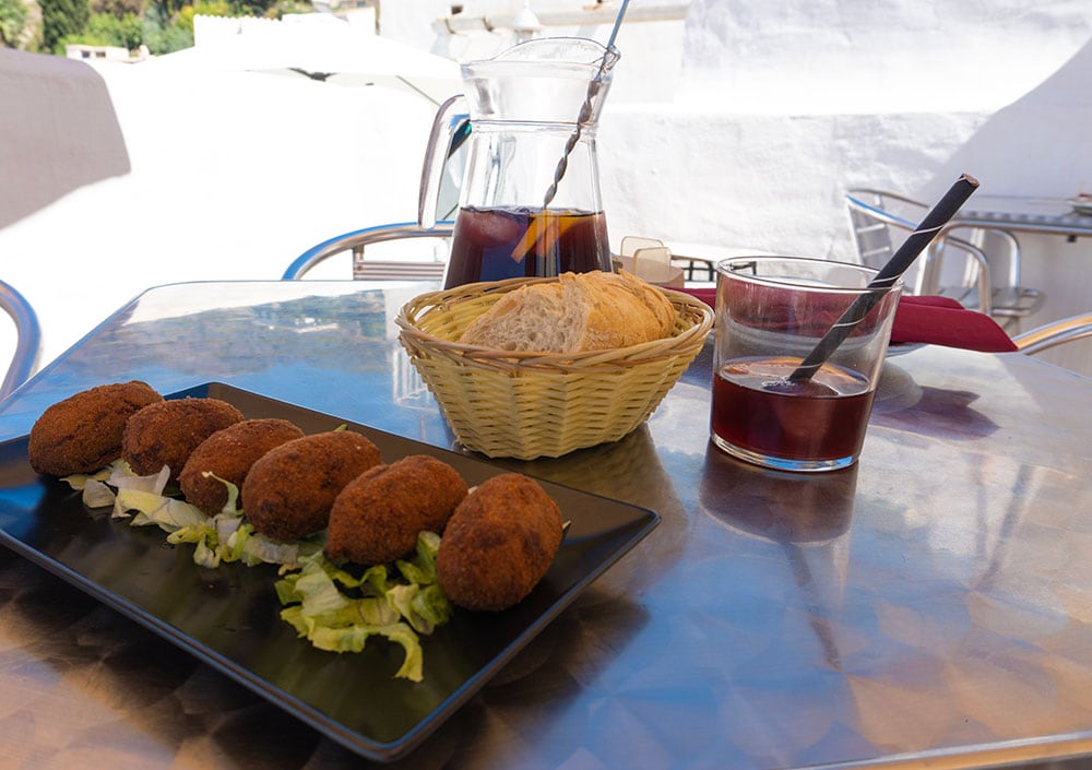 Photos of  a glass of sangria and mushroom croquettes.