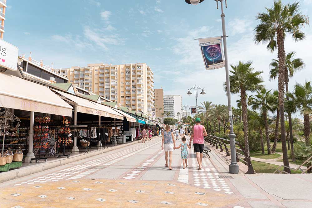 a family walking on the beach promenade in benalmadena, spain