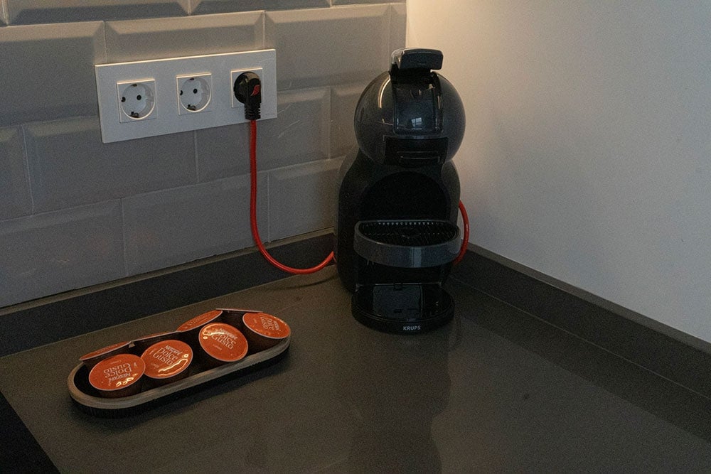 Close up photo of a nespresso coffee machine next to a small tray with capsules.