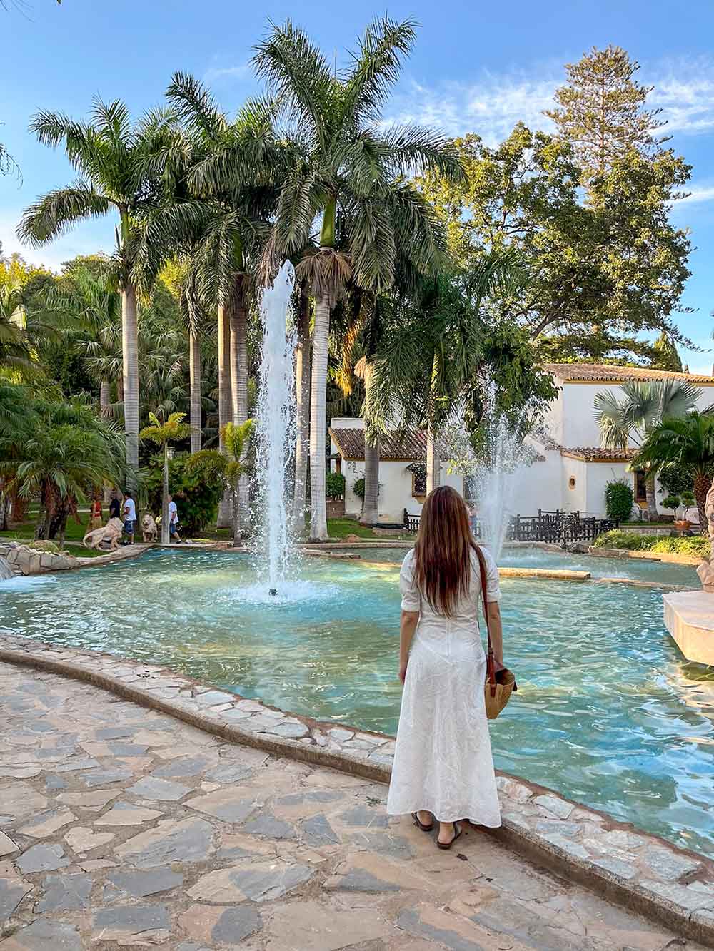 Woman wearing a long white dress in Molino de Inca Botanical Garden in Torremolinos.