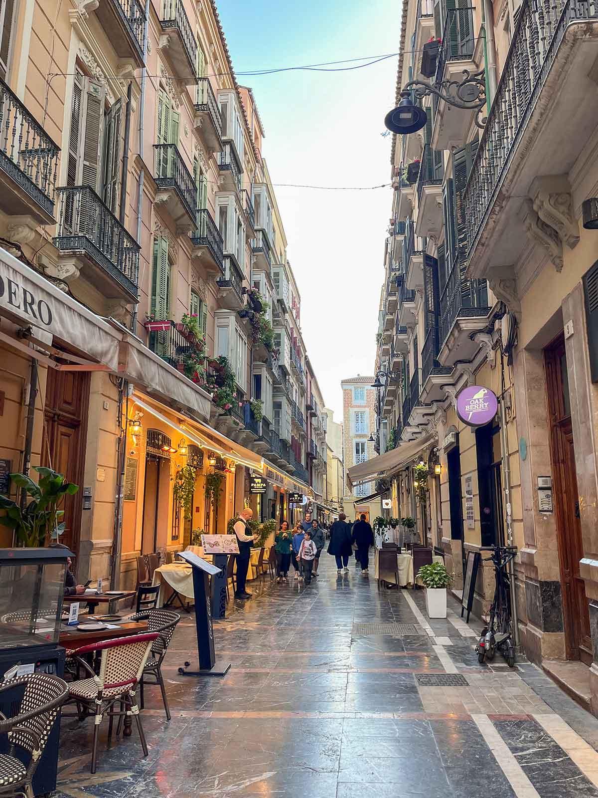A street with restaurants in Malaga city centre in winter.