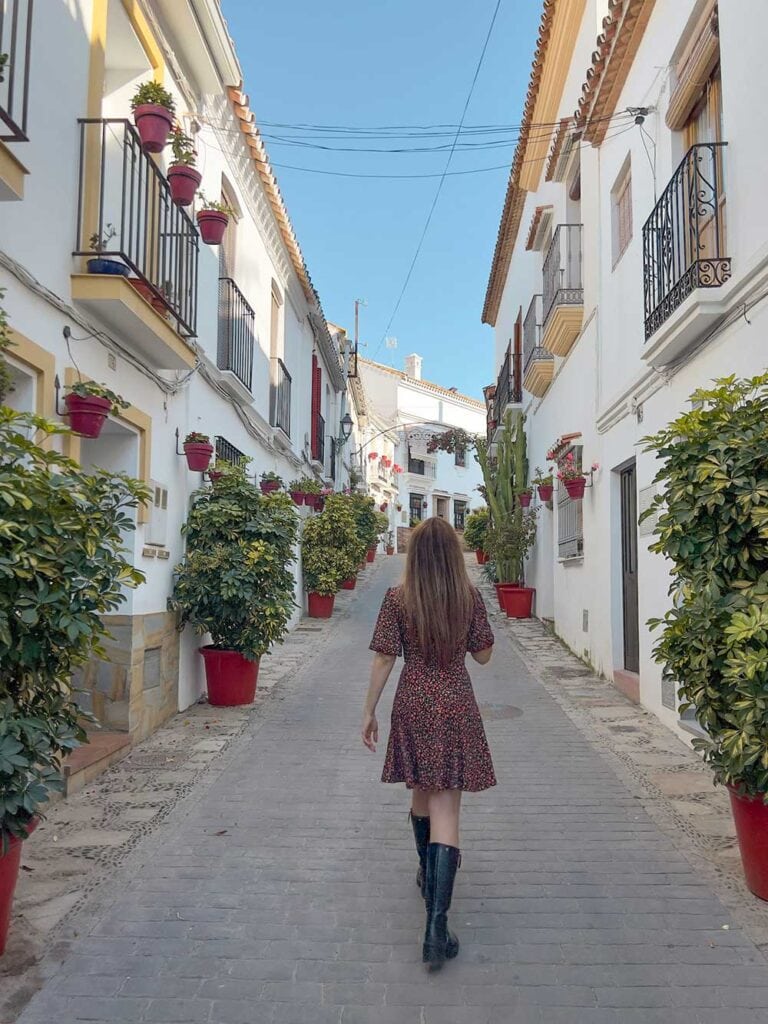 Cristina walking down a street in the historic centre of Estepona, Spain.