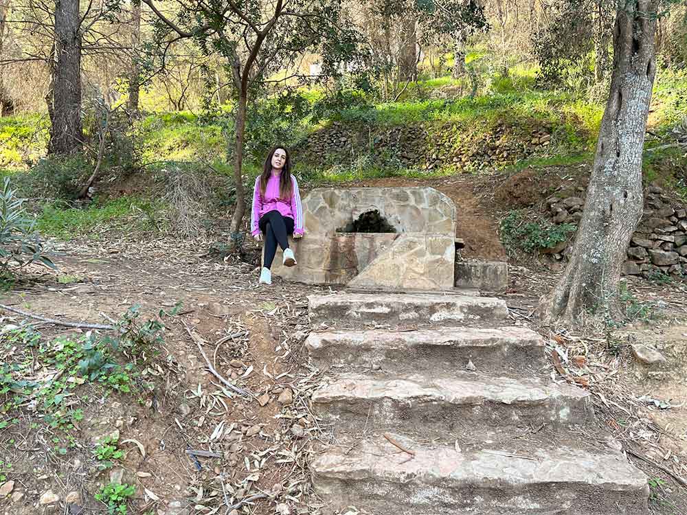 Cristina sat next to a fountain located in the Jarapalos hiking trail in Alhaurin de la Torre, Spain.