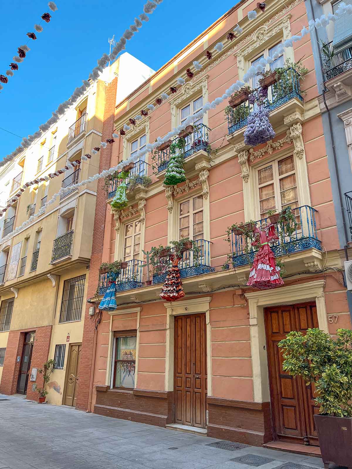 Flamenco dresses hanging down balconies in El Perchel, Malaga.