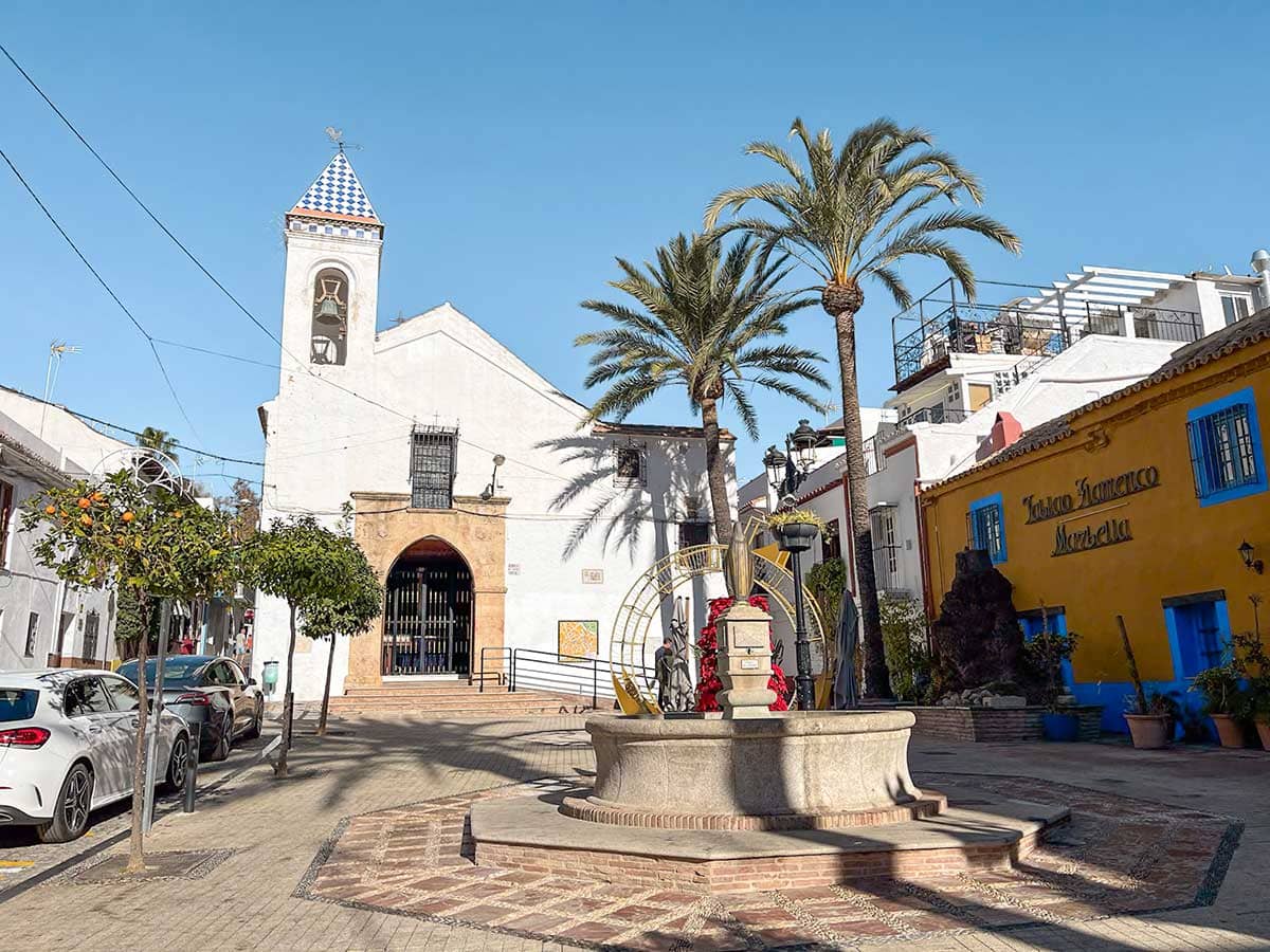 Square with a fountain and white church in Marbella old town, Southern Spain.