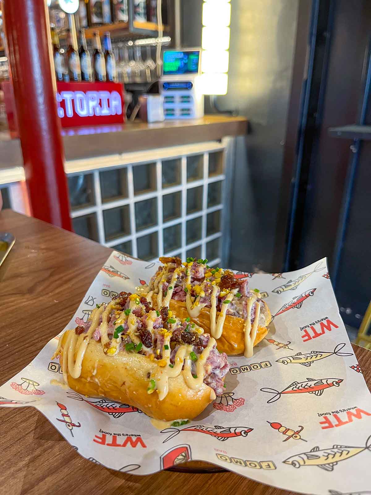 A photo of a brioche bun with salchichon tartar and Pedro Ximenez sauce.
