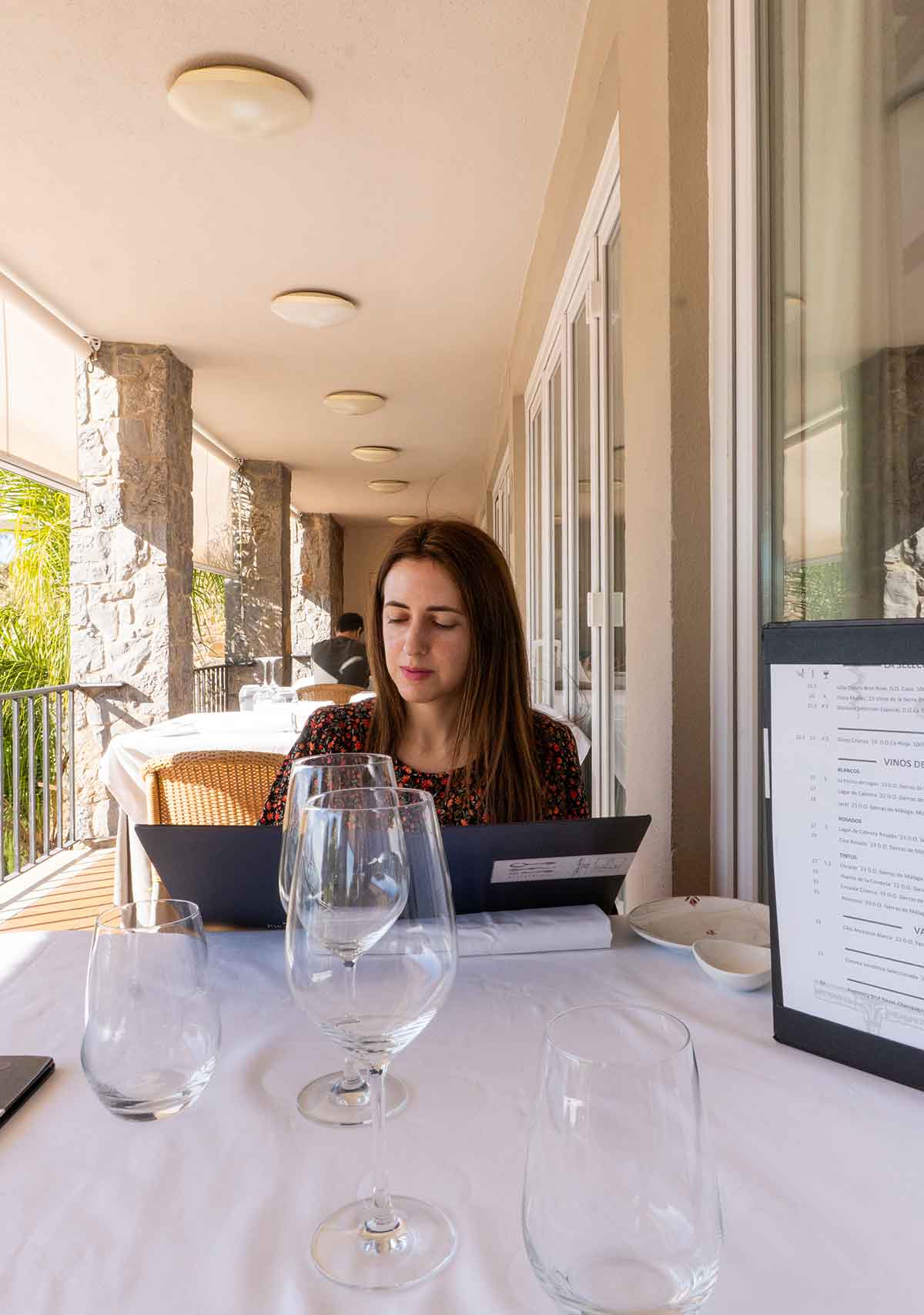 Woman reading the food menu at Restaurante Parador Gibralfaro in Malaga.