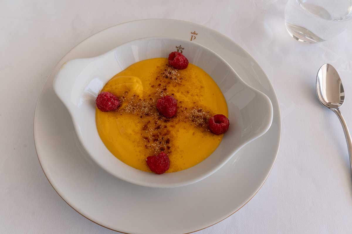 Crema catalana dessert made with mangoes, brown sugar and raspberries.