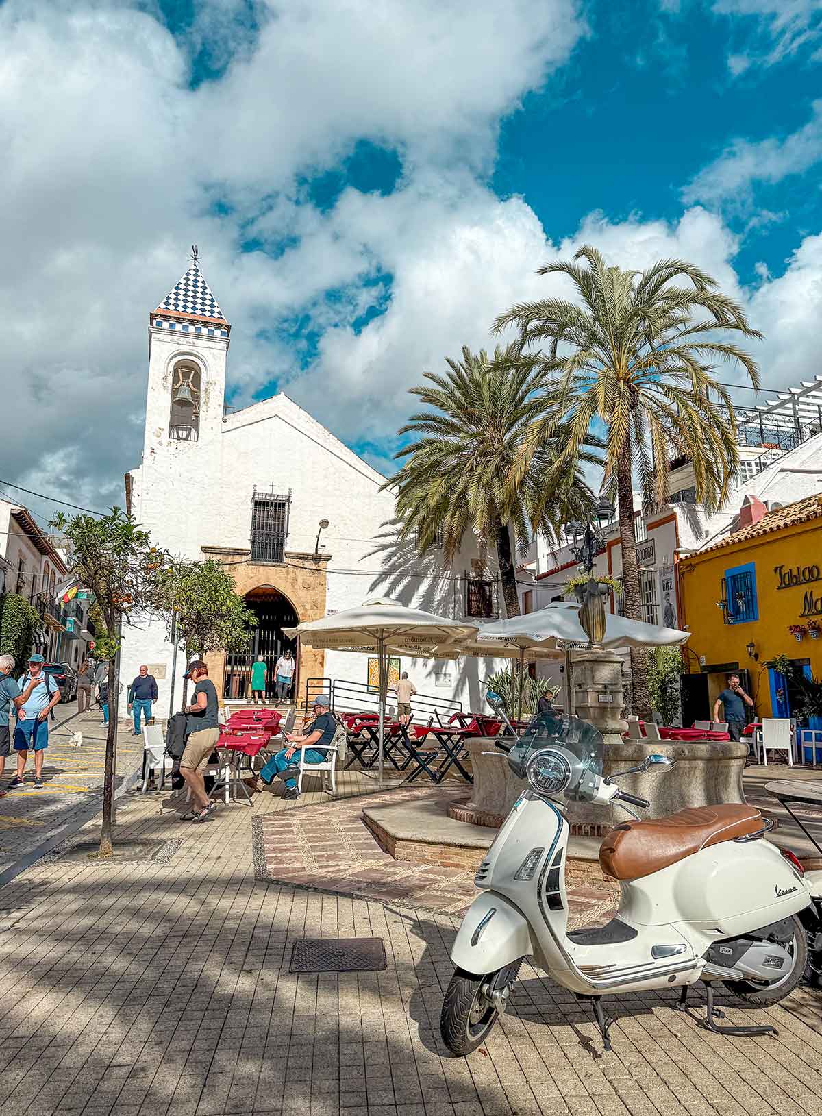 Marbella Old Town Santo Cristo Square with white motorbike and church in the background.