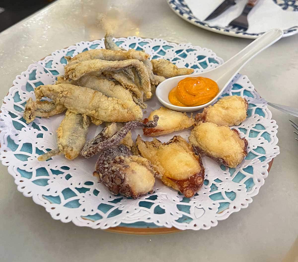 A close up photo of fried anchovies and octopus at Taberna la Niña del Pisto restaurant in Marbella.
