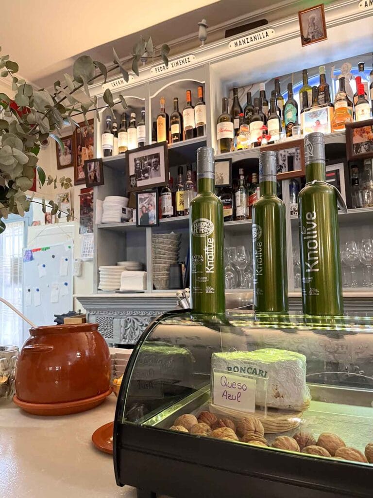 Wine bottles, olive oil and cheese in the bar of Taberna la Niña del Pisto restaurant in Marbella.