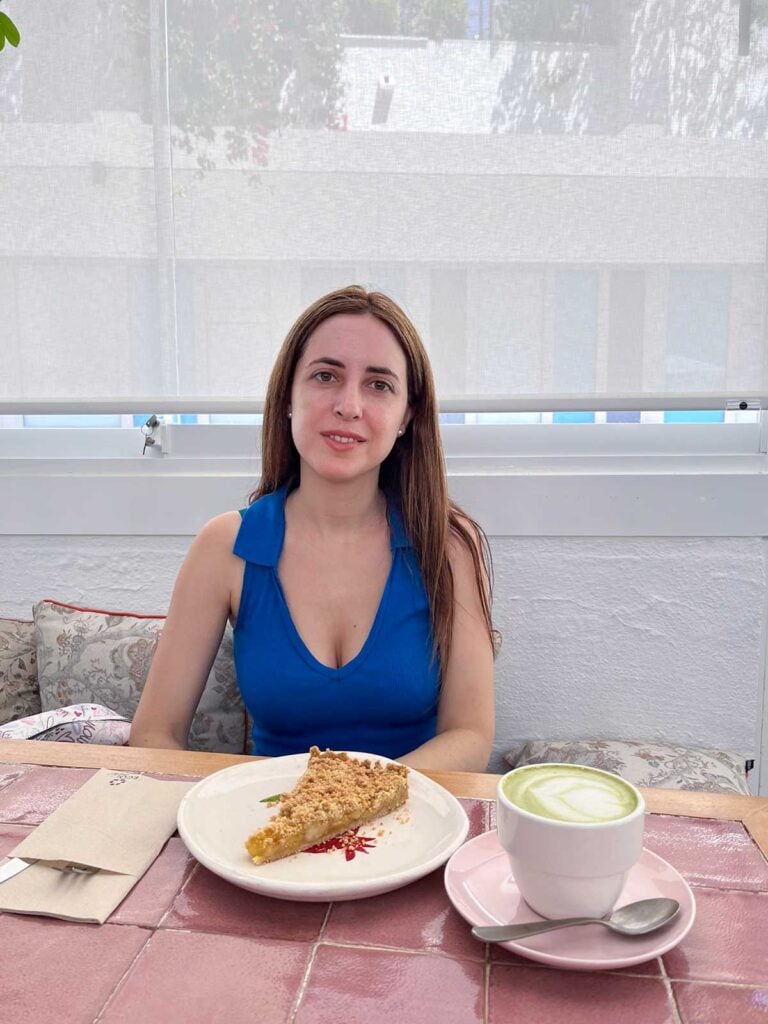 Cristina having apple pie and a matcha latte at Le Petit Jardin Cafe in Marbella.