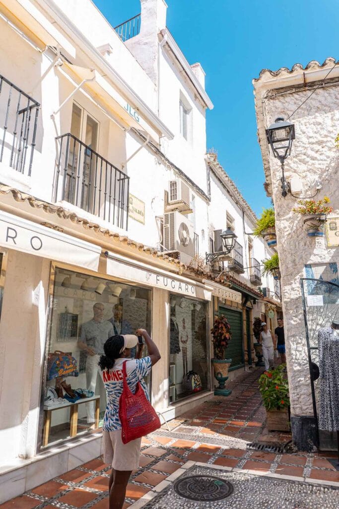 How to Spend 4 Days in Marbella (Slow Travel Guide) 3 A woman taking a picture of the building in Calle Gloria, Marbella Old Town.