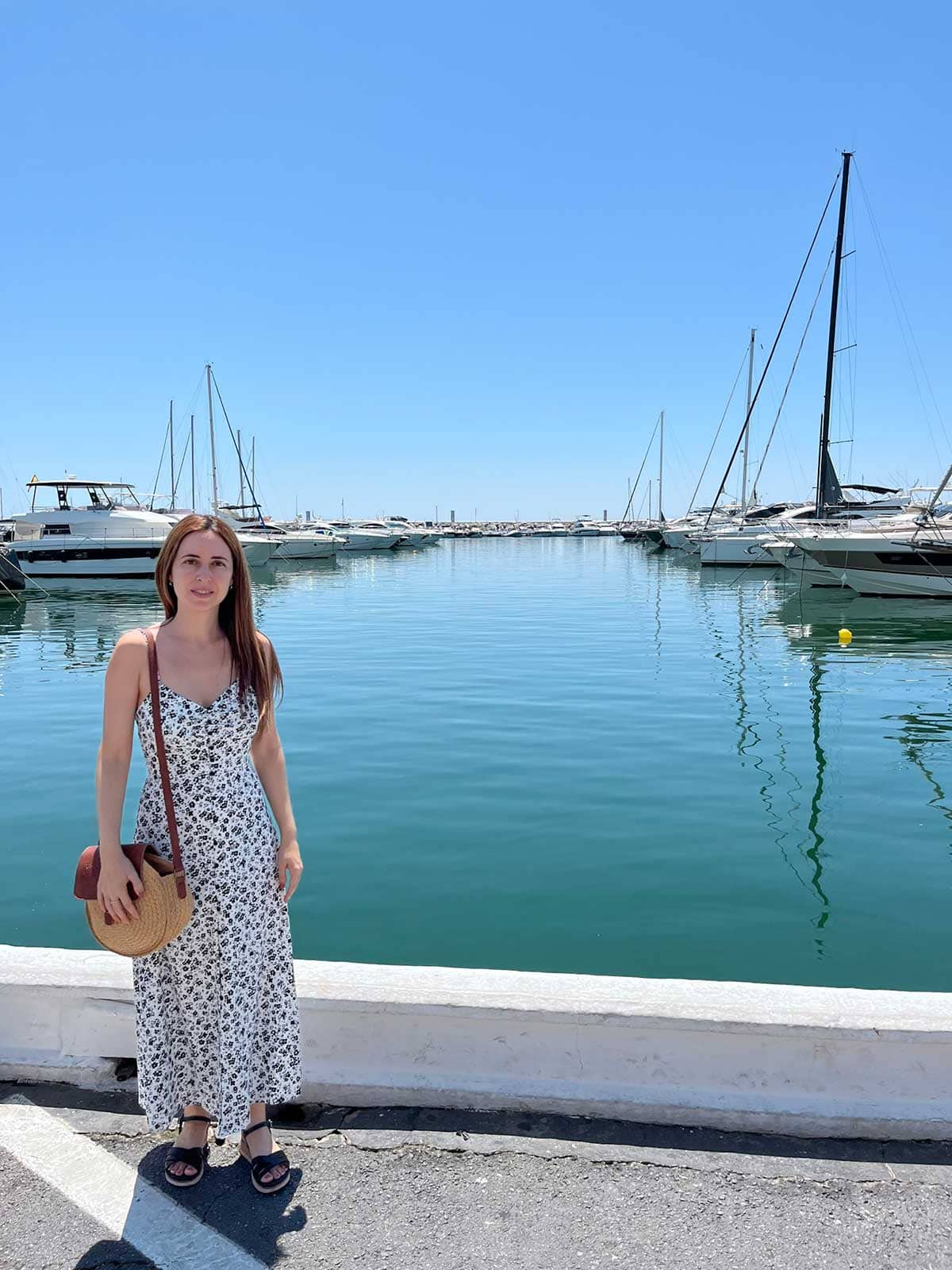 Woman wearing a white and black dress in Puerto Banus, Marbella, Spain.