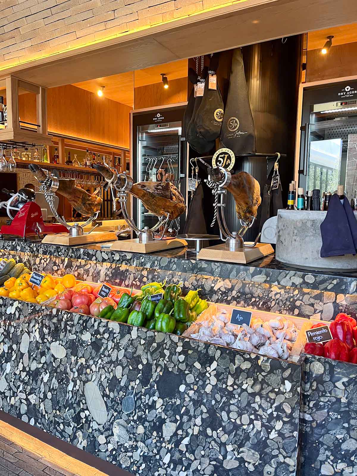 Ham leg and seasonal vegetables at Tragabuches restaurant bar in Marbella, Spain.