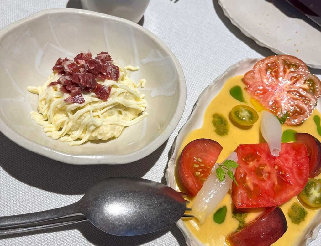 A plate with Russian Salad and another one with a tomato salad.