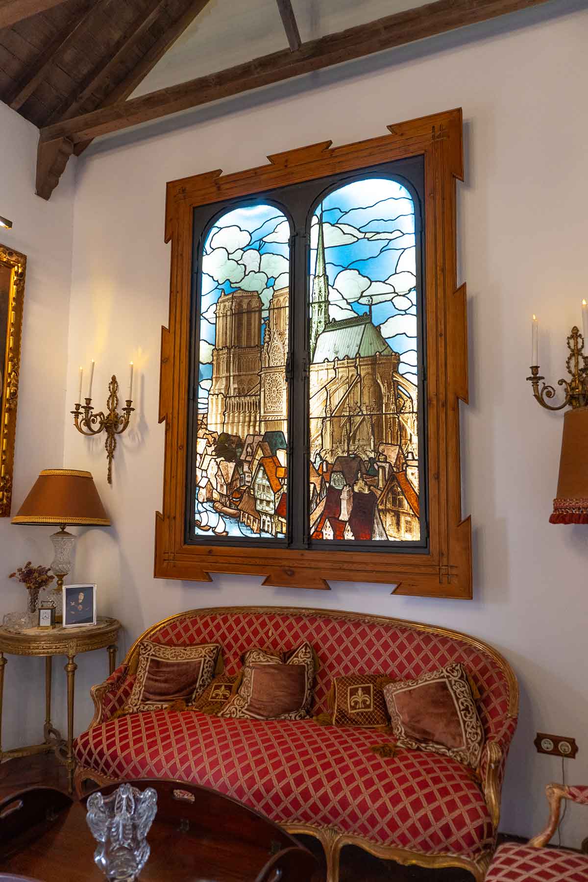 A photo of a beautiful stained glass window and old-fashioned sofa in the glass museum of Malaga, Spain.