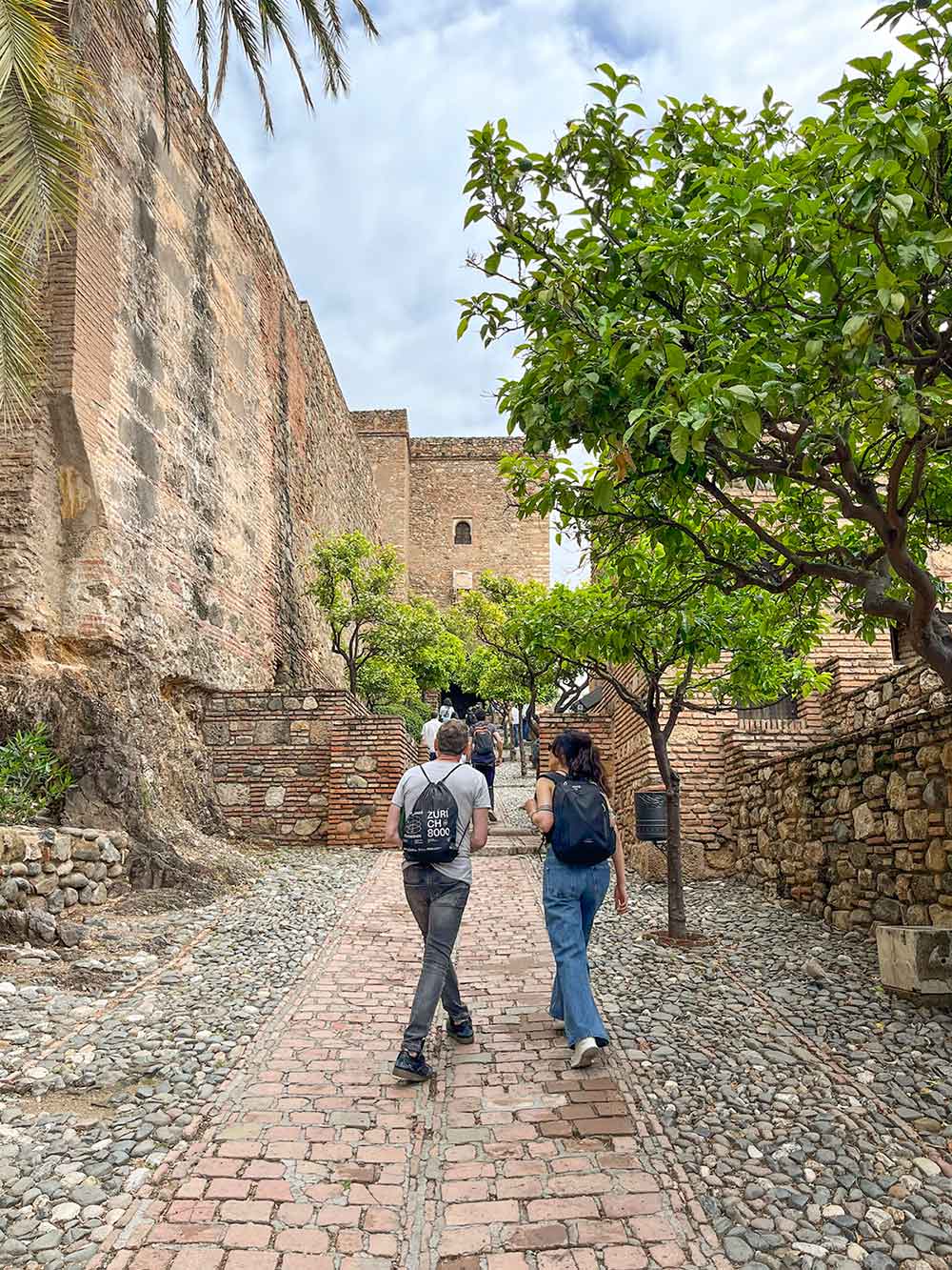 The Ultimate Guide to Exploring Alcazaba de Malaga 4 A couple walking up the hill in the Alcazaba of Malaga, Spain.