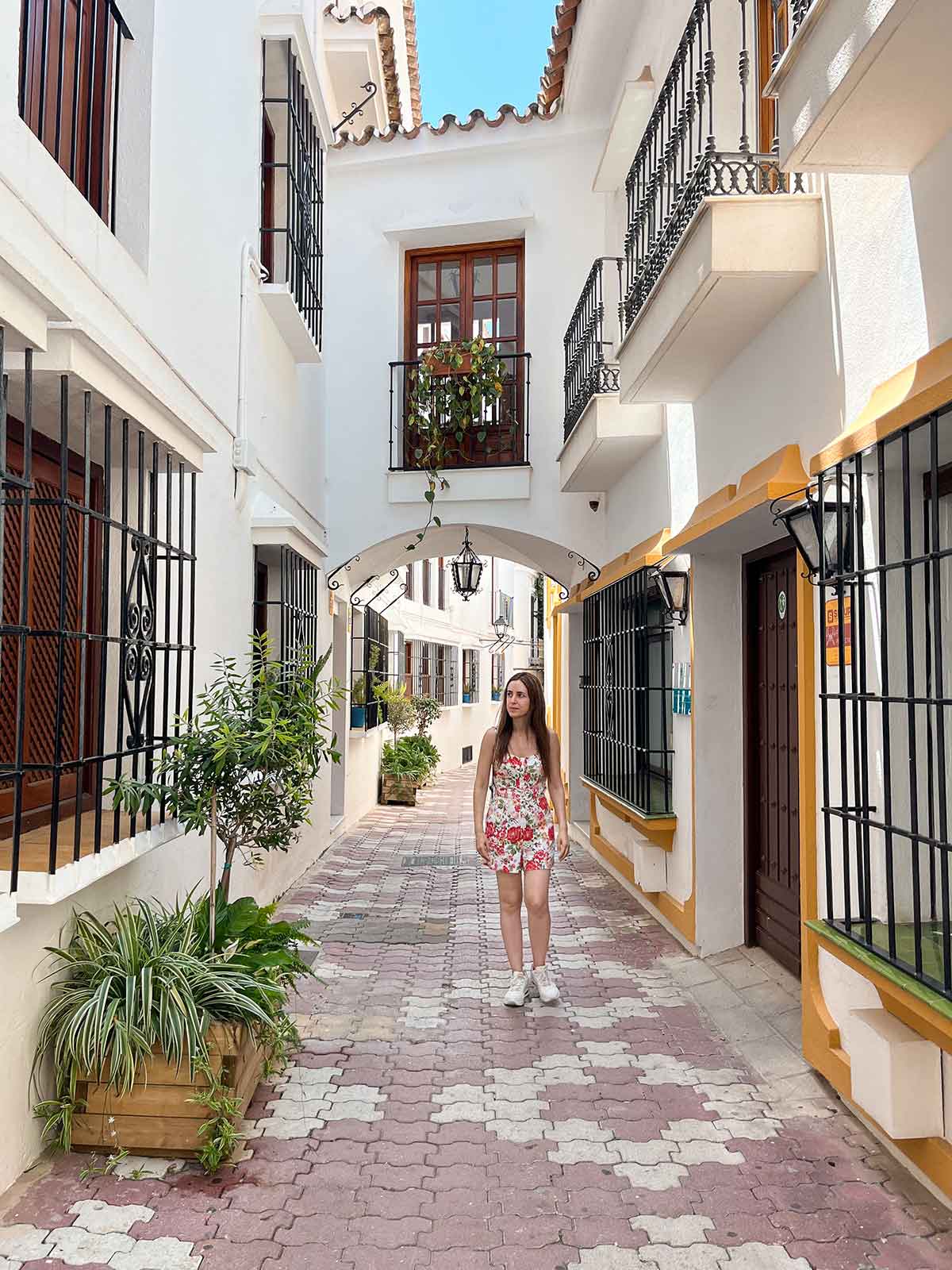 Woman walking down Calle Caballeros in Marbella Old Town.