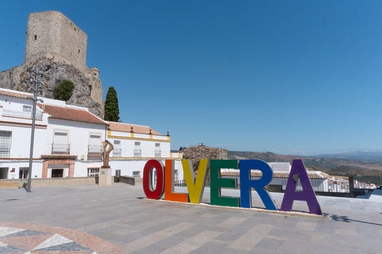 9 Best Things to Do in Olvera, Cadiz 1 Multicoloured sign that reads Olvera and a side view of the castle.