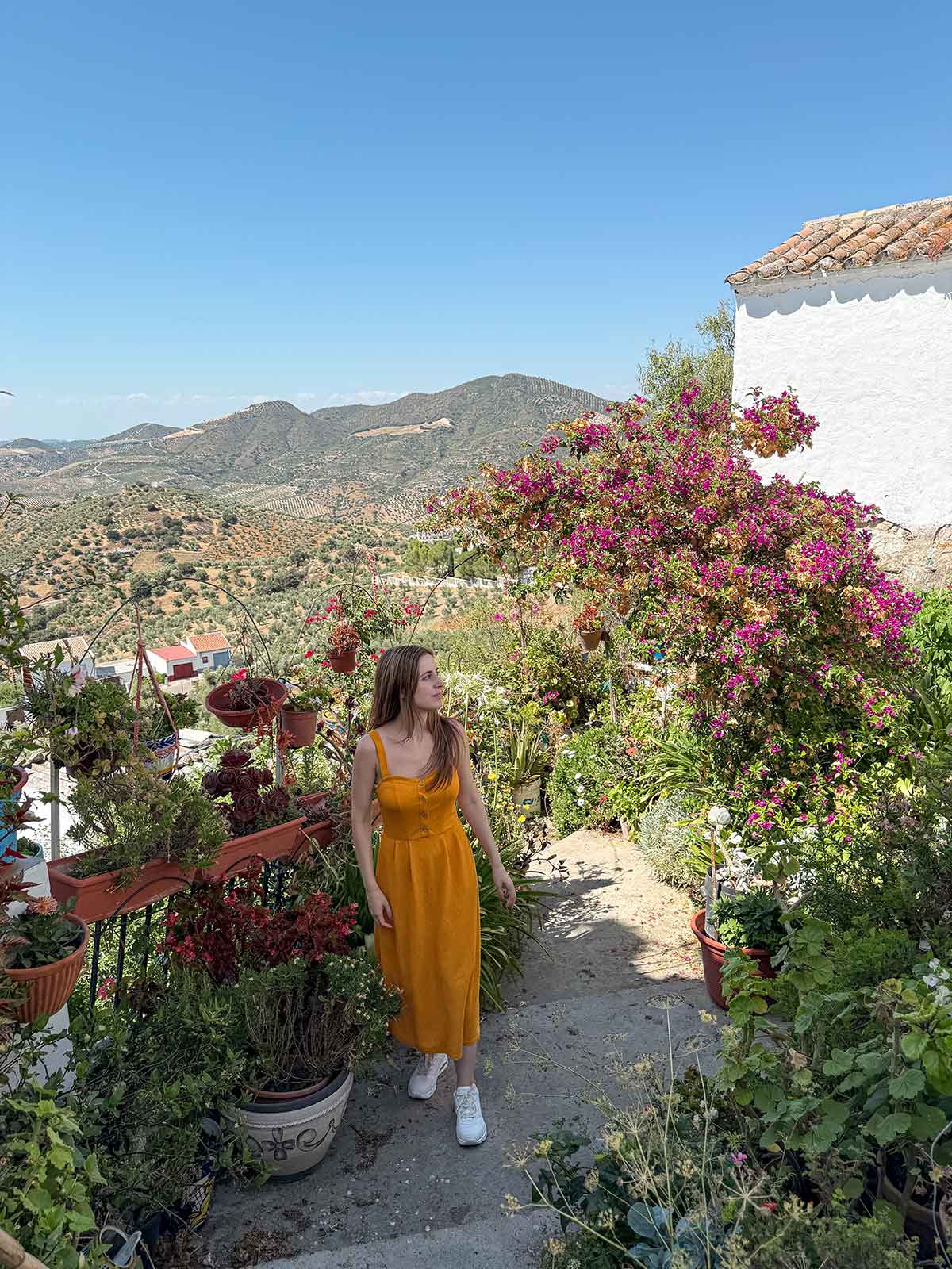 Cristina at a viewpoint surrounded by plants and flowers in Olvera.