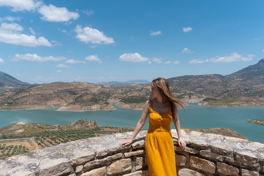 10 Best Things to Do in Zahara de la Sierra 4 Woman admiring the mountain and reservoir views from a viewpoint in Zahara de la Sierra, Cadiz.