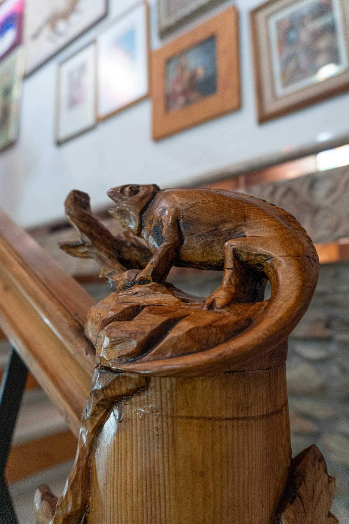 A close up photo of a wooden sculpture of a chamaleon.