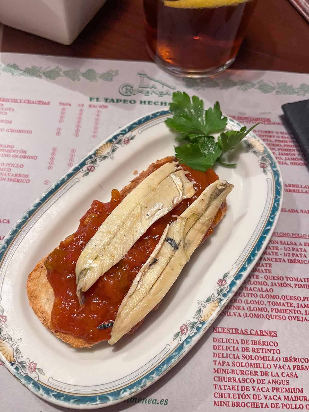 Anchovies with tomato sauce in a cracker.