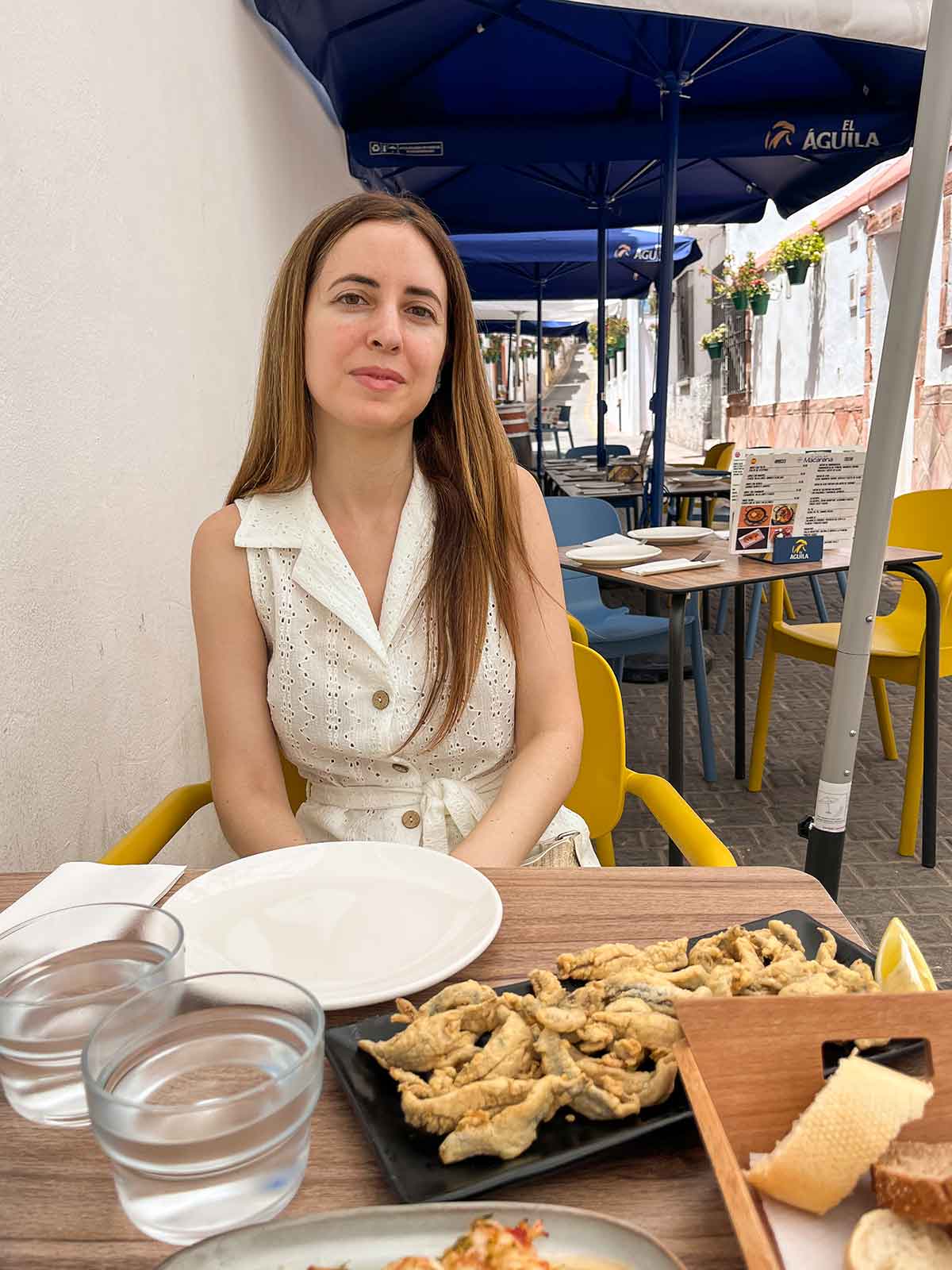 Where to Eat in Estepona (My Top Recommendations) 16 Cristina eating fried anchovies with lemon at El Patio del Macarena tapas bar in Estepona old town.