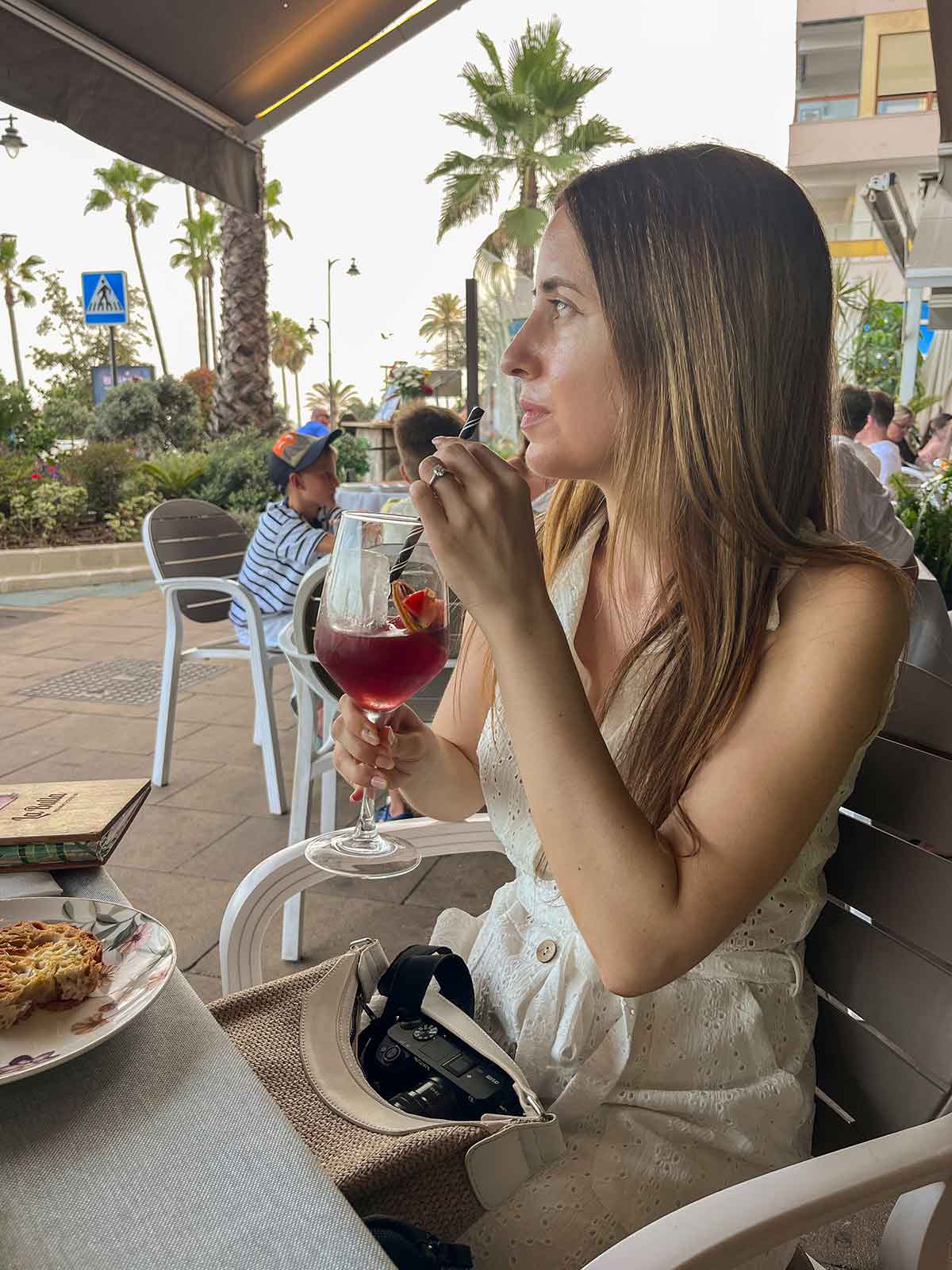 Where to Eat in Estepona (My Top Recommendations) 12 Cristina drinking sangria at La Bulla Gastrobar in Estepona, Malaga, Spain.